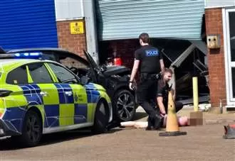 Moment car ploughs into unit at business park – before police pin down shirtless man